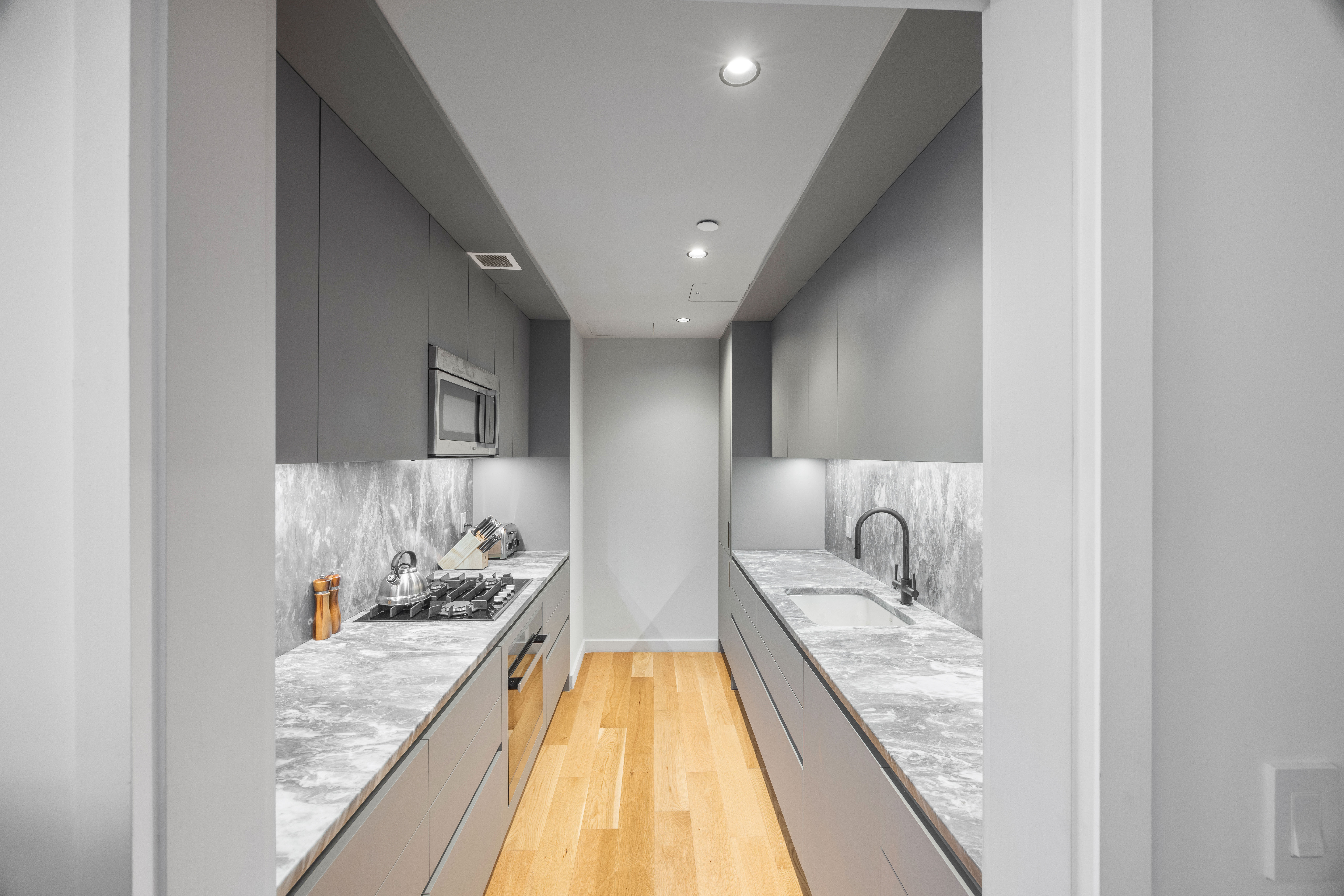 547 West 47th Street, Unit 509 Manhattan, NY 10036 - Photo 7 of 29 a bathroom with a granite countertop sink and a mirror