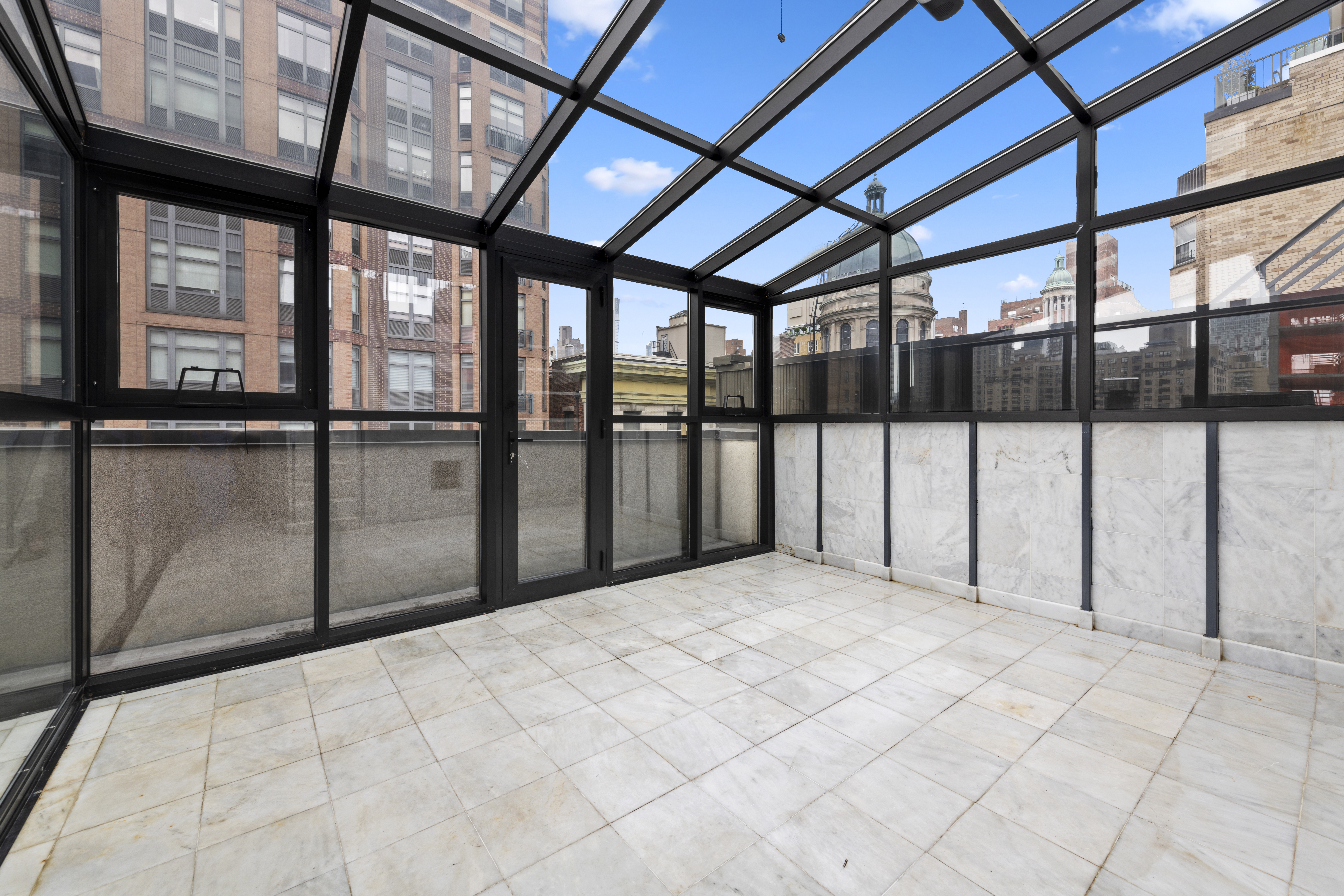 195 East 76th Street Manhattan, NY 10021 - Photo 10 of 20 a view of an empty room with a balcony and furniture