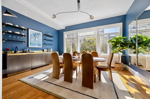 a dining room with furniture and a floor to ceiling window