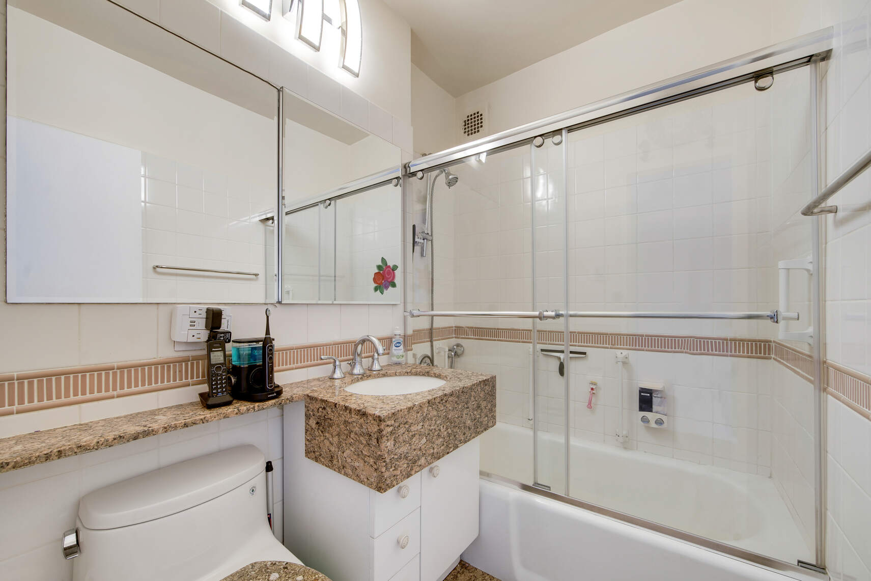 300 East 74th Street, Unit 14F Manhattan, NY 10021 - Photo 8 of 13 a bathroom with a granite countertop sink a toilet and bathtub