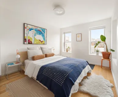 a bedroom with a bed and a window