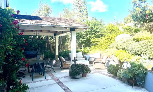 a view of a patio with couches table and chairs and potted plants