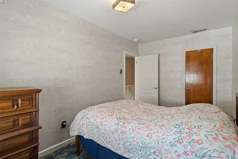 a bedroom with a bed and a dresser