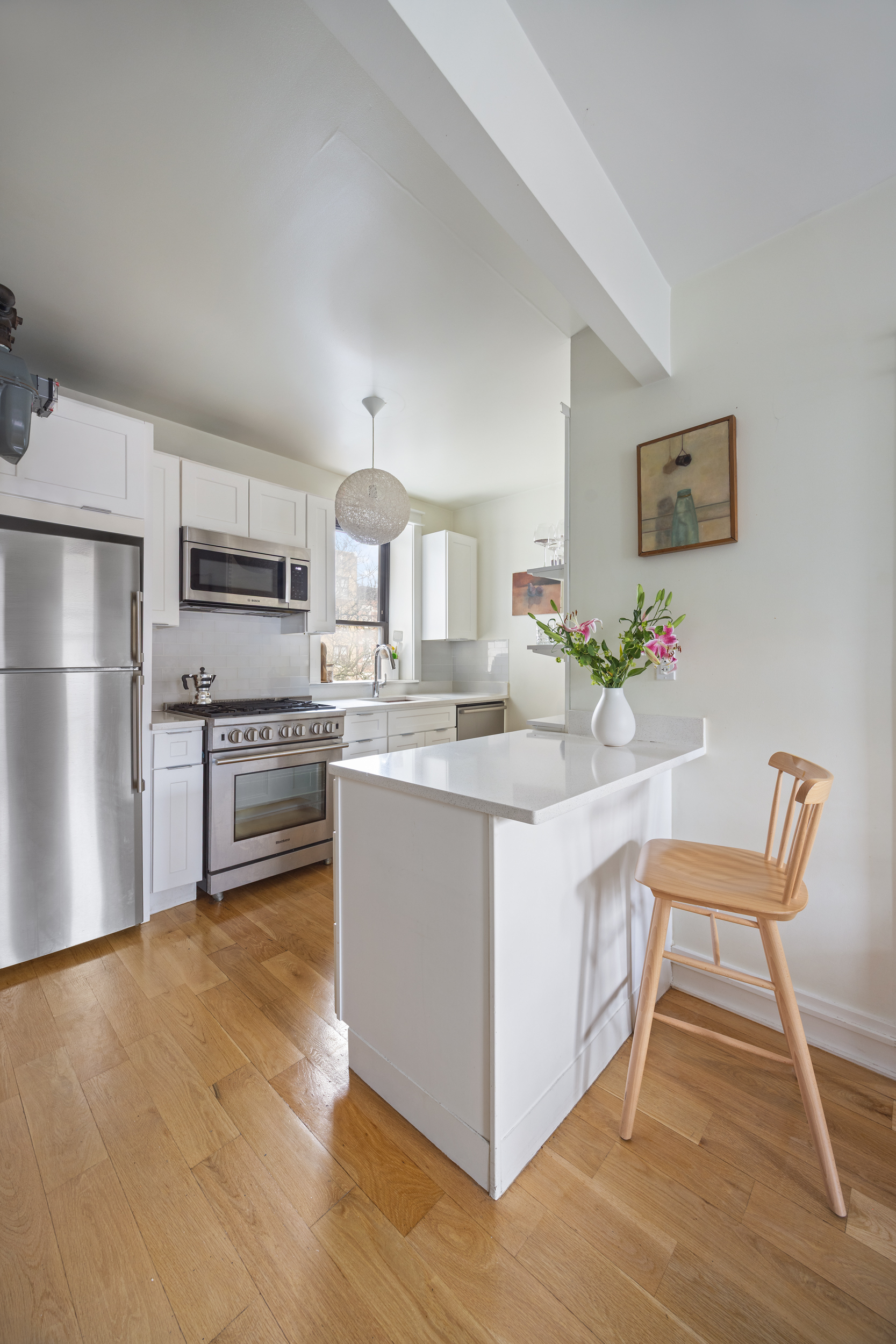 342 West 21st Street, Unit 4B Manhattan, NY 10011 - Photo 3 of 9 a kitchen with stainless steel appliances granite countertop a white cabinets and a refrigerator