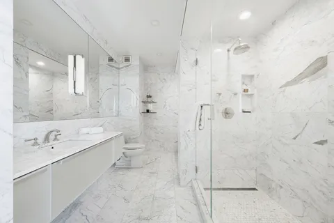 a bathroom with a sink a toilet and shower