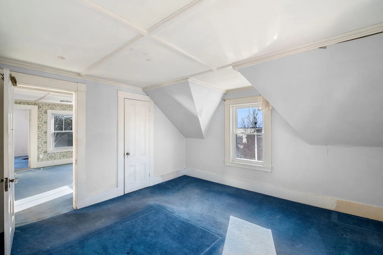 an empty room with wooden floor and white walls