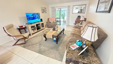 a living room with furniture and a painting on the wall