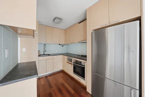 a kitchen with a sink a refrigerator and cabinets