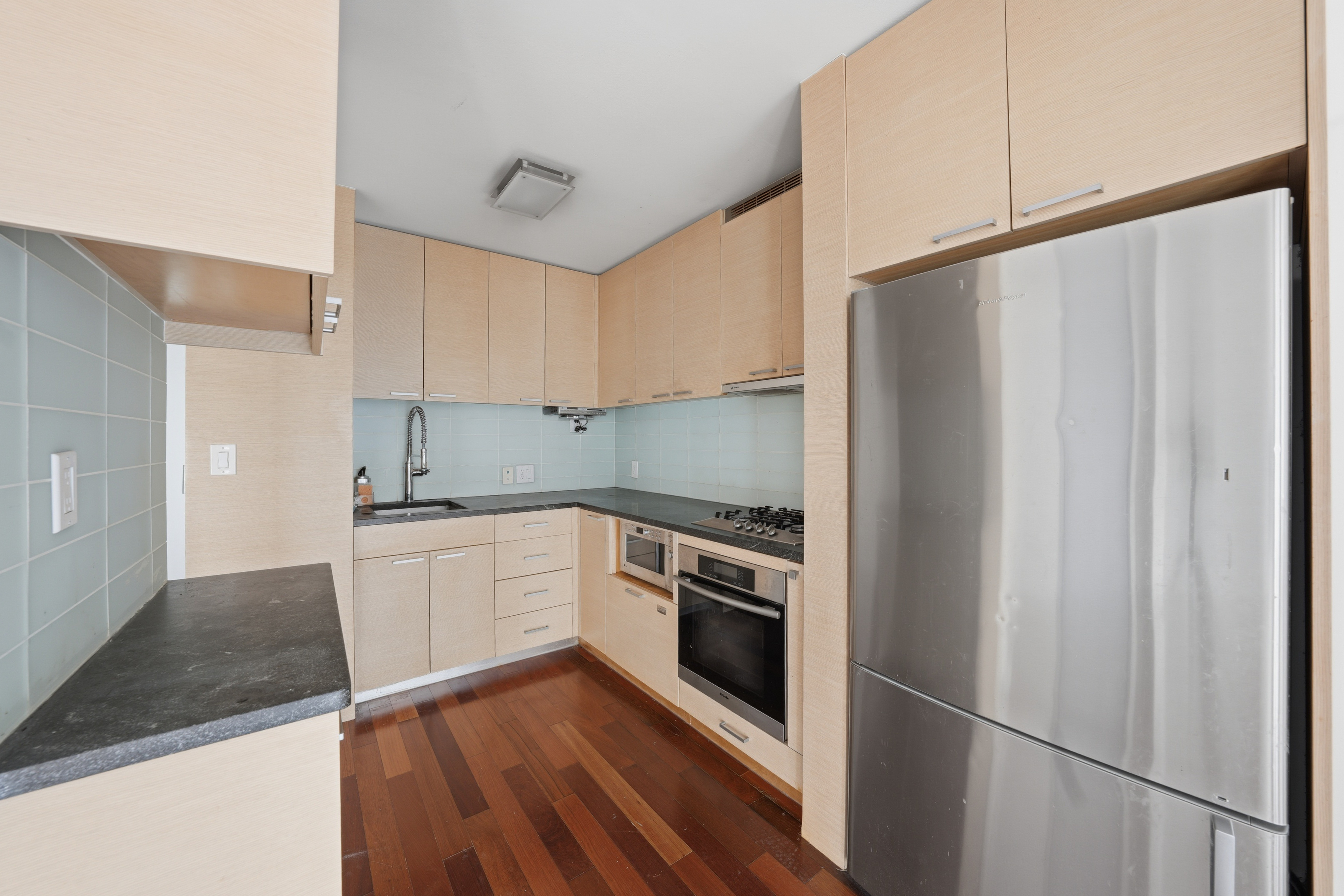 206 East 95th Street, Unit 6B Manhattan, NY 10128 - Photo 15 of 25 a kitchen with a sink a refrigerator and cabinets
