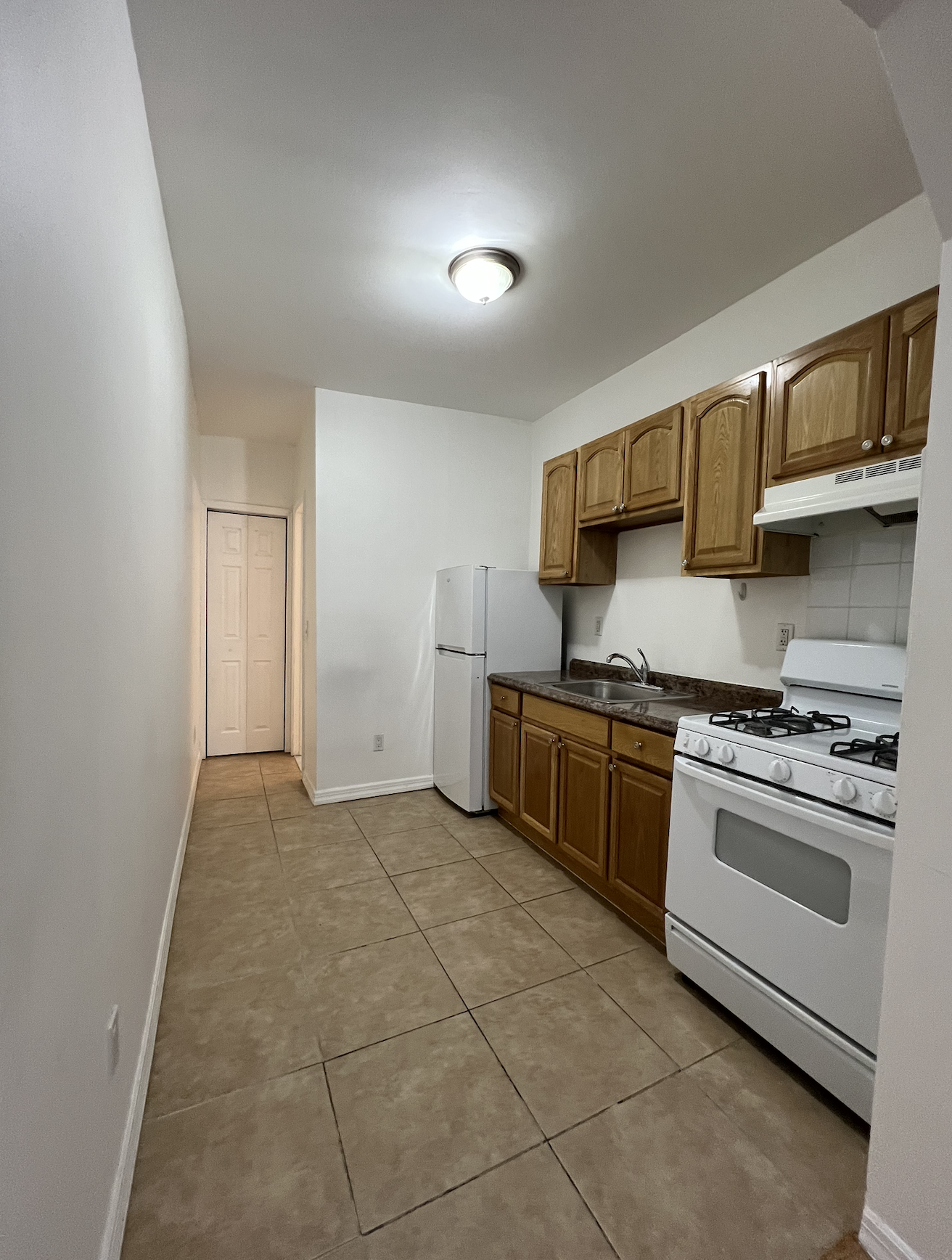 446 West 46th Street, Unit 5 Manhattan, NY 10036 - Photo 5 of 15 a kitchen with stainless steel appliances granite countertop a stove a sink and a refrigerator