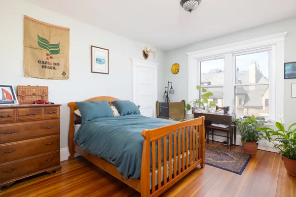 a bedroom with two beds and a potted plant