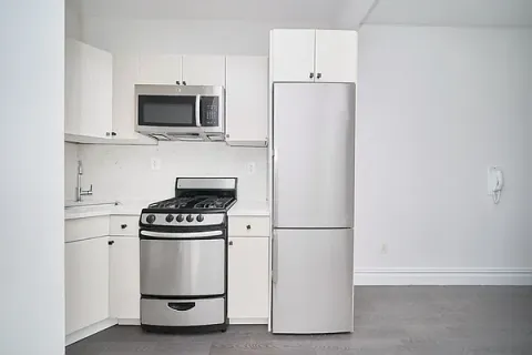 a kitchen with white cabinets and stainless steel appliances