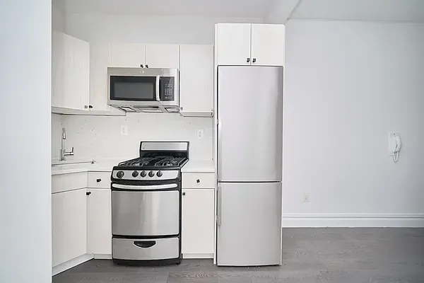 a kitchen with white cabinets and stainless steel appliances
