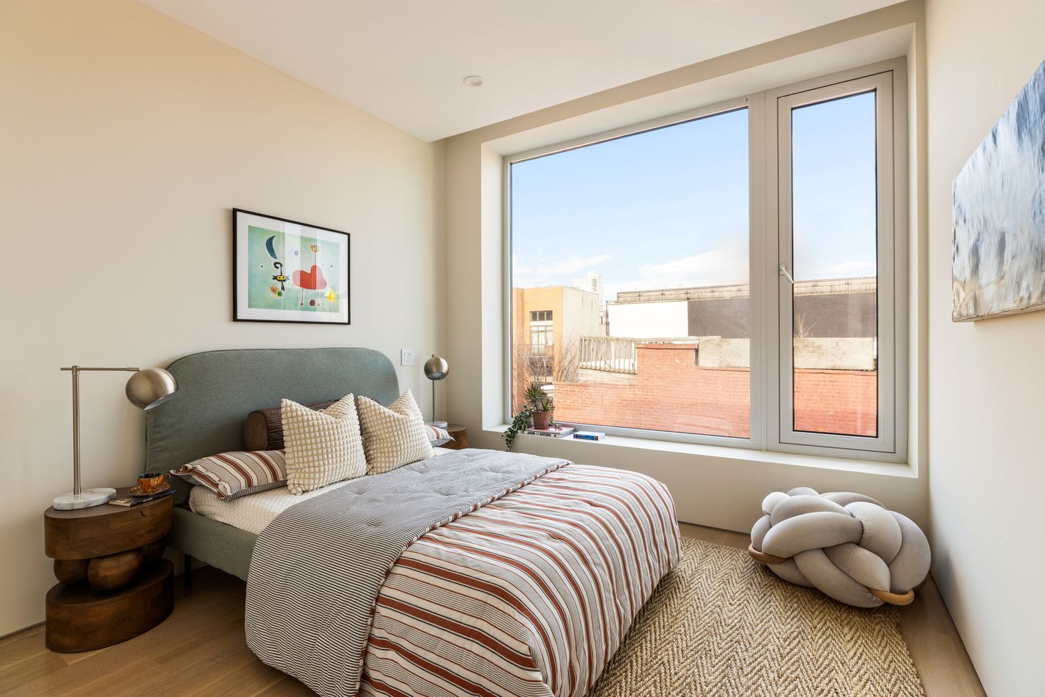 a bedroom with a bed and a large window