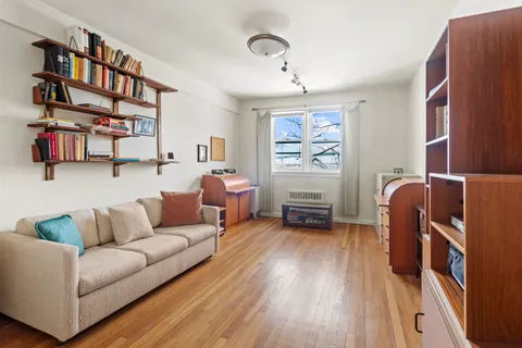 a living room with furniture and a book shelf