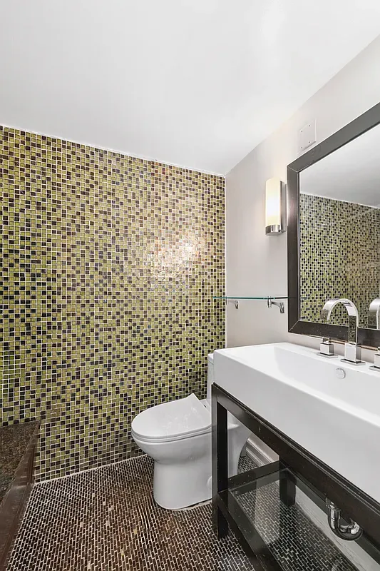 a bathroom with a sink toilet and a mirror