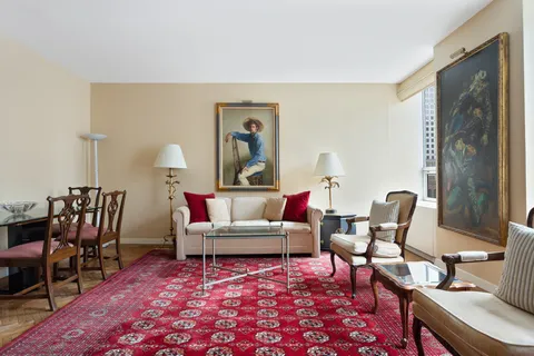a living room with furniture a rug and a table