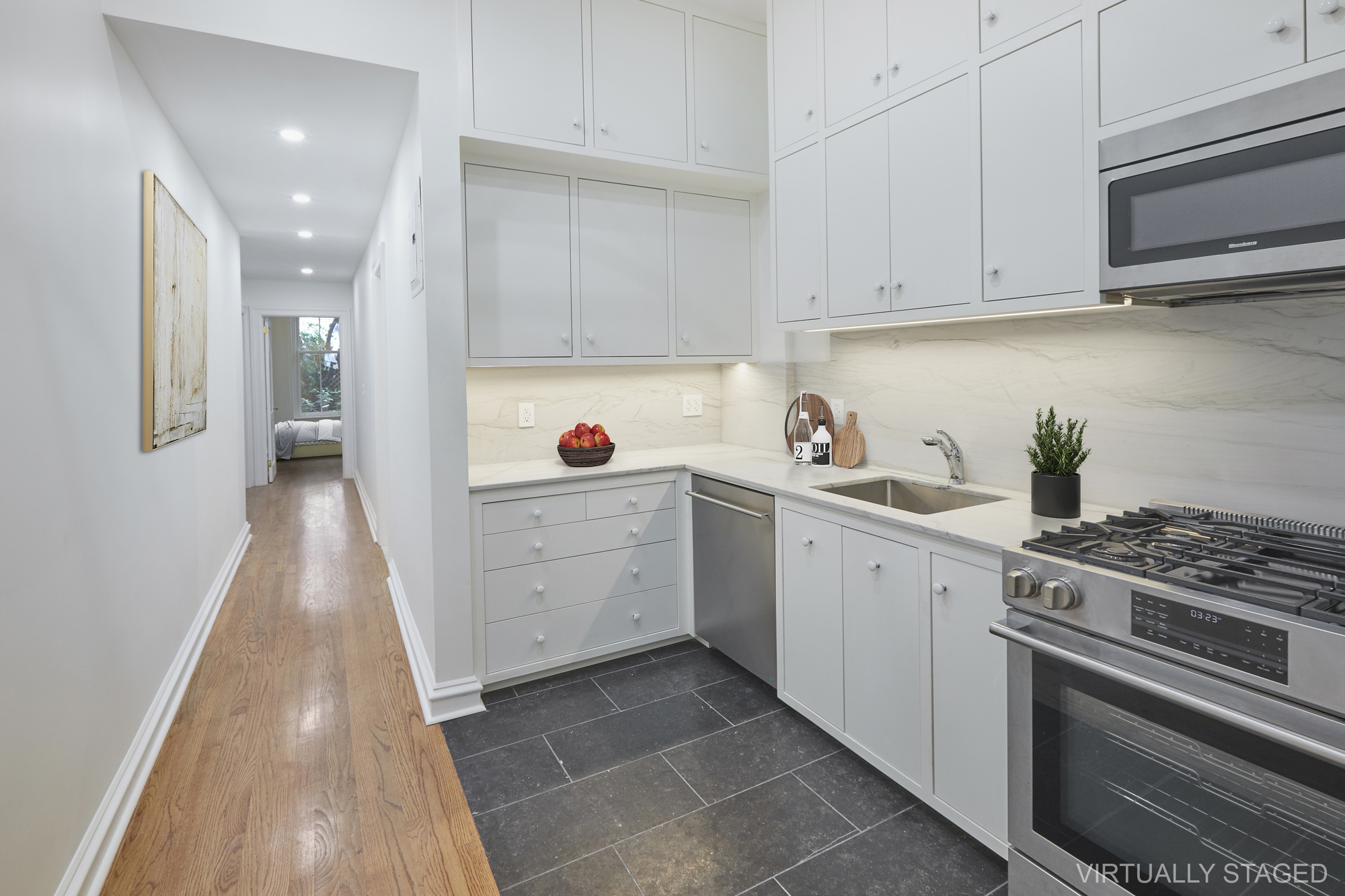 157 East 75th Street, Unit 1E Manhattan, NY 10021 - Photo 4 of 21 a kitchen with white cabinets and appliances