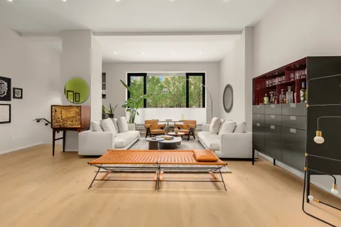 a living room with furniture a window and a flat screen tv