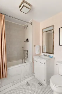 a bathroom with a sink a toilet a mirror and shower