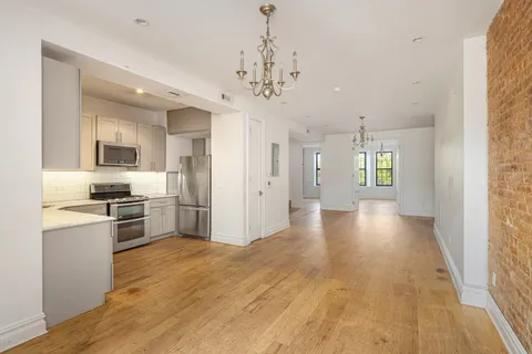 a view of a kitchen with a sink a refrigerator and window