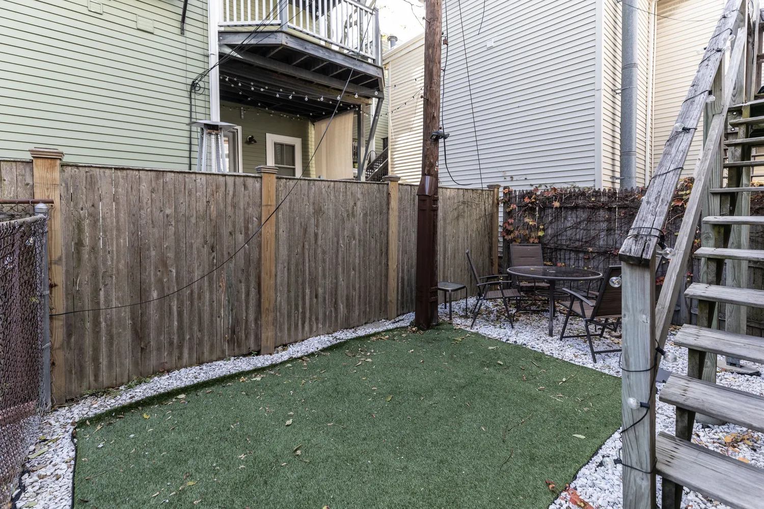 a backyard of a house with table and chairs