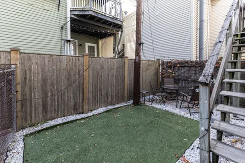 a backyard of a house with table and chairs
