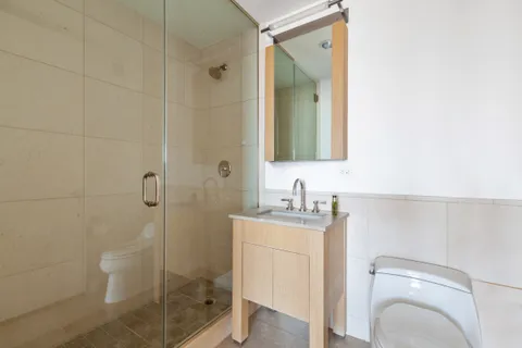 a bathroom with a granite countertop sink a toilet and shower