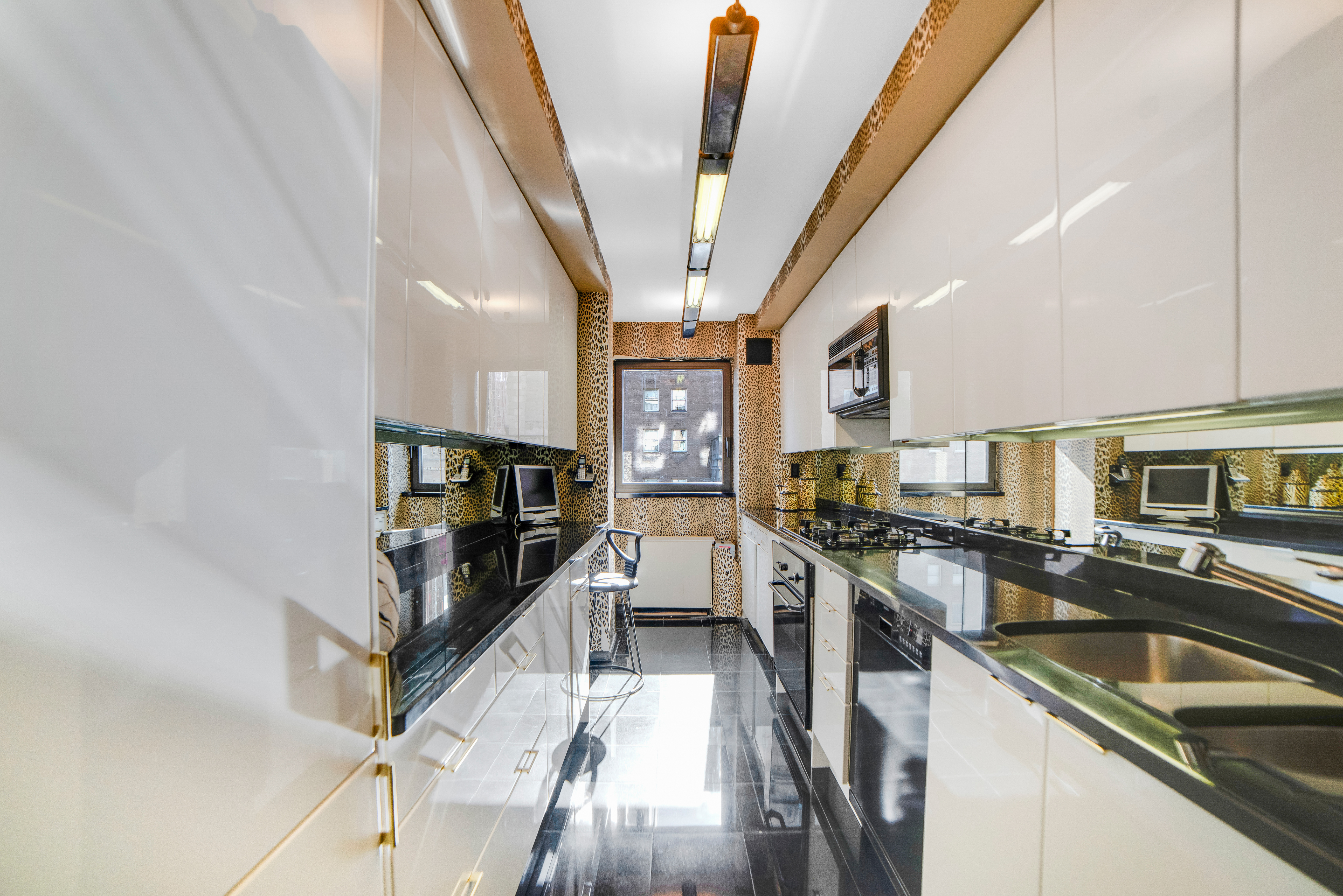 200 Central Park South, Unit 24A Manhattan, NY 10019 - Photo 14 of 23 a kitchen with stainless steel appliances granite countertop a sink a stove and cabinets