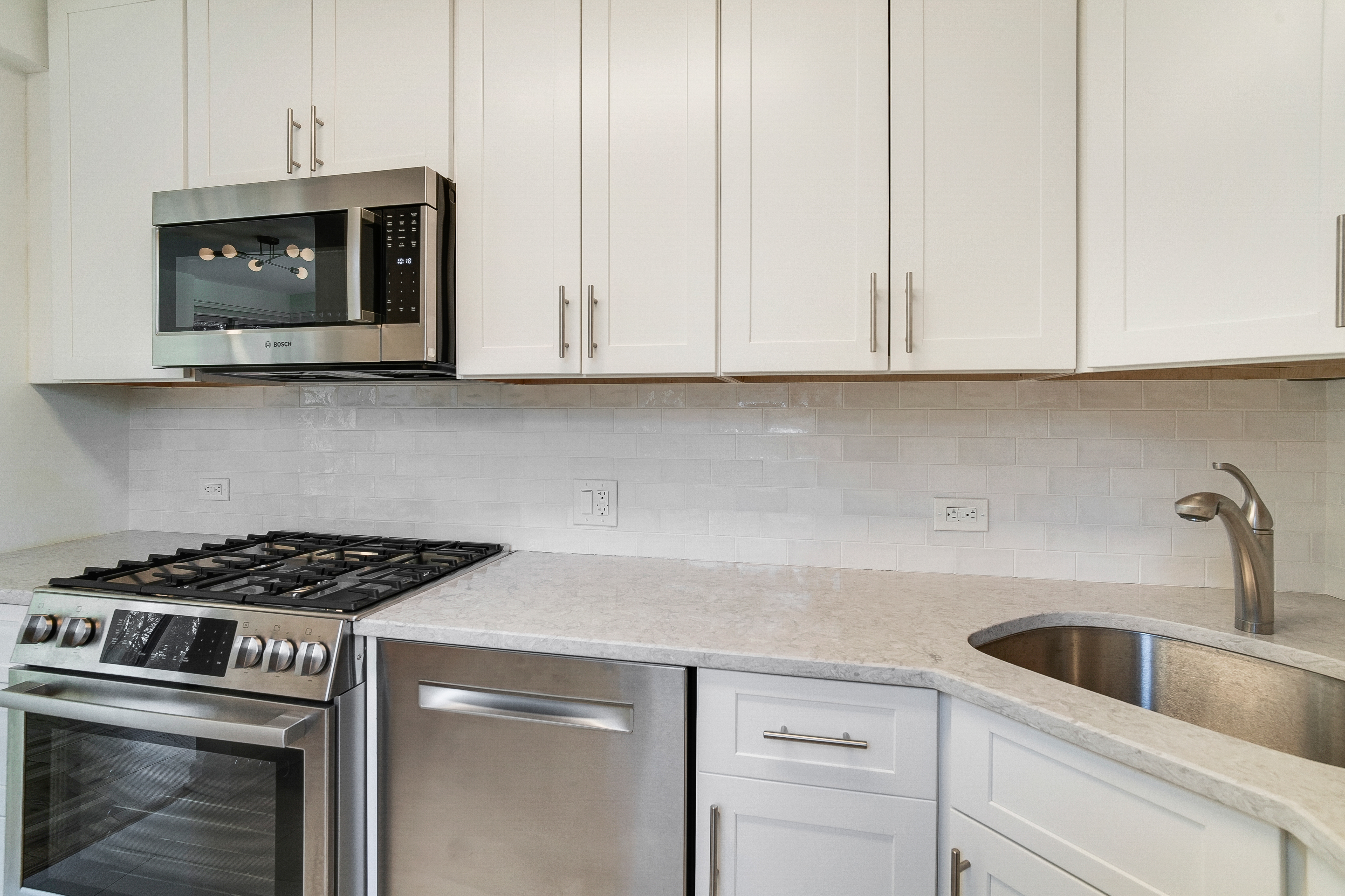 4455 Douglas Avenue, Unit 8A Bronx, NY 10471 - Photo 7 of 22 a kitchen with granite countertop white cabinets and stainless steel appliances