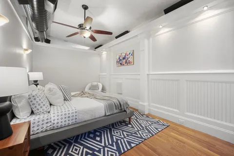 a bedroom with bed and wooden floor