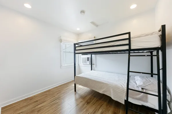 a bedroom with a bed and wooden floor