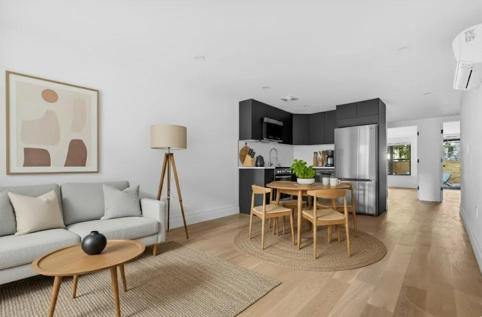 a living room with furniture and a dining table with kitchen view