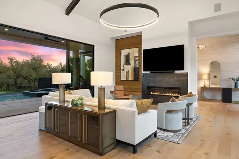 a living room with furniture a flat screen tv and a large window