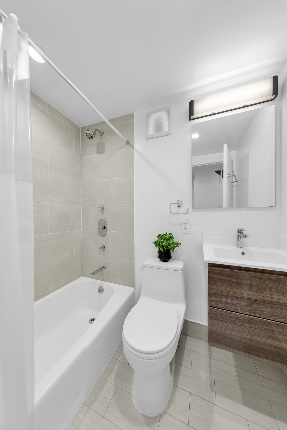 215 East 24th Street, Unit 602 Manhattan, NY 10010 - Photo 6 of 8 a bathroom with a sink a toilet and bathtub