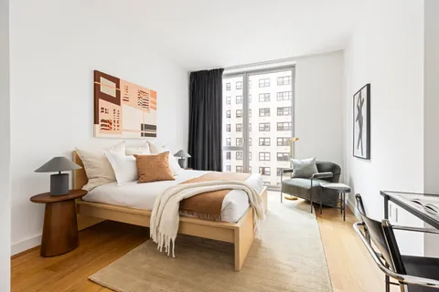 a bedroom with furniture and a large window