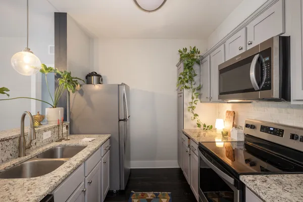 a kitchen with stainless steel appliances granite countertop a sink a stove and a microwave