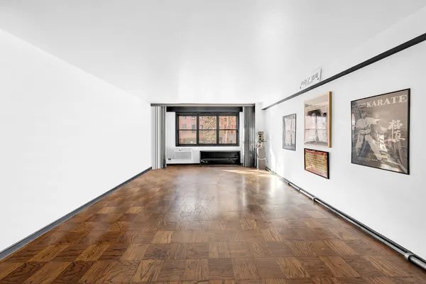 a view of a big room with wooden floor and windows