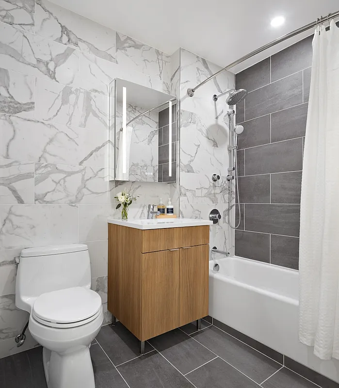 666 Greenwich Street, Unit 350 Manhattan, NY 10014 - Photo 6 of 13 a bathroom with a sink a toilet and shower