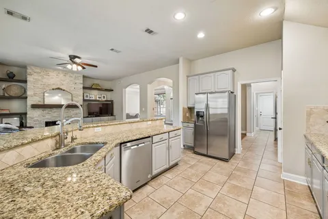 a kitchen with stainless steel appliances granite countertop a sink and a refrigerator