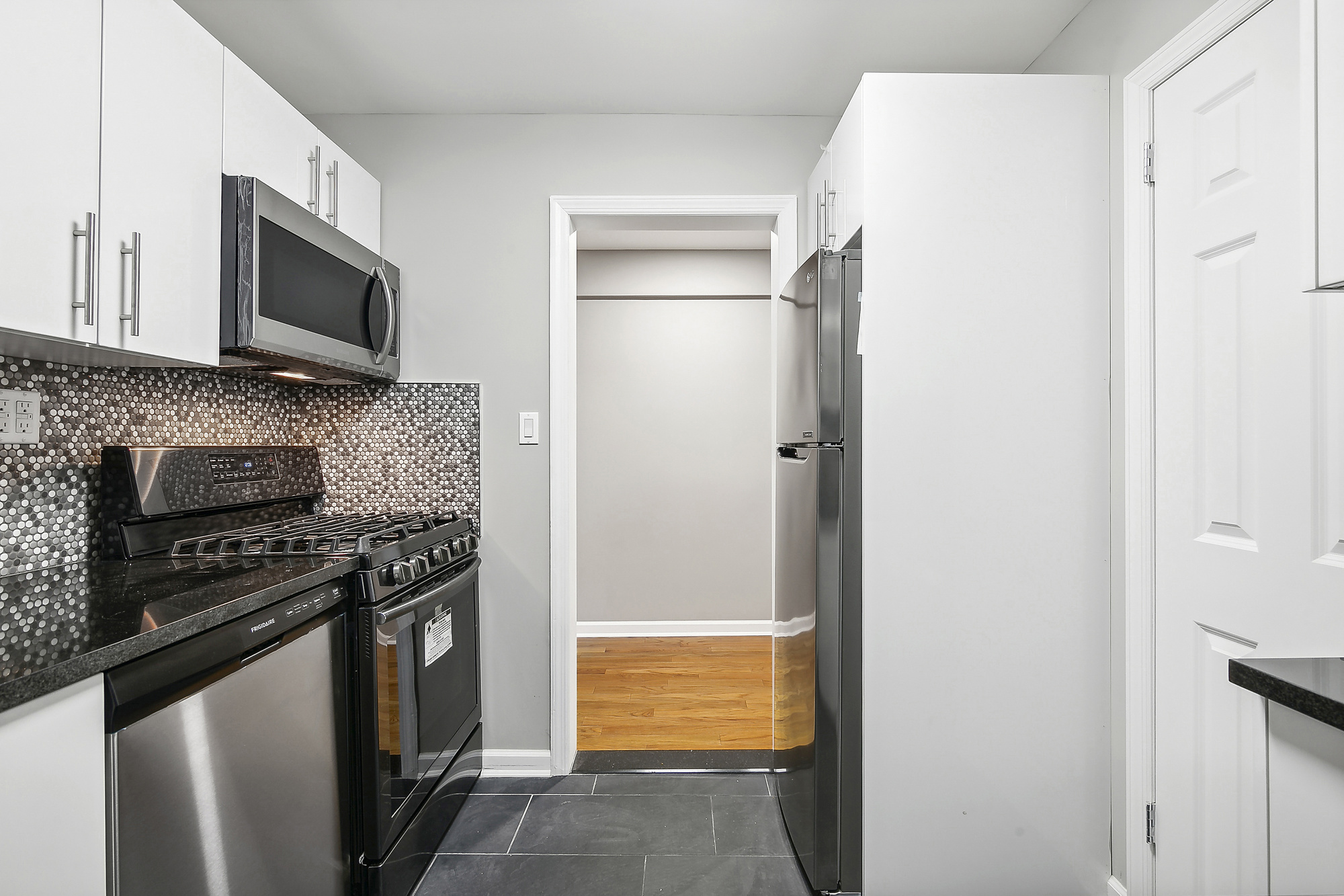 40 89th Street, Unit 1F Brooklyn, NY 11209 - Photo 4 of 13 a kitchen with stainless steel appliances a stove a microwave and a refrigerator