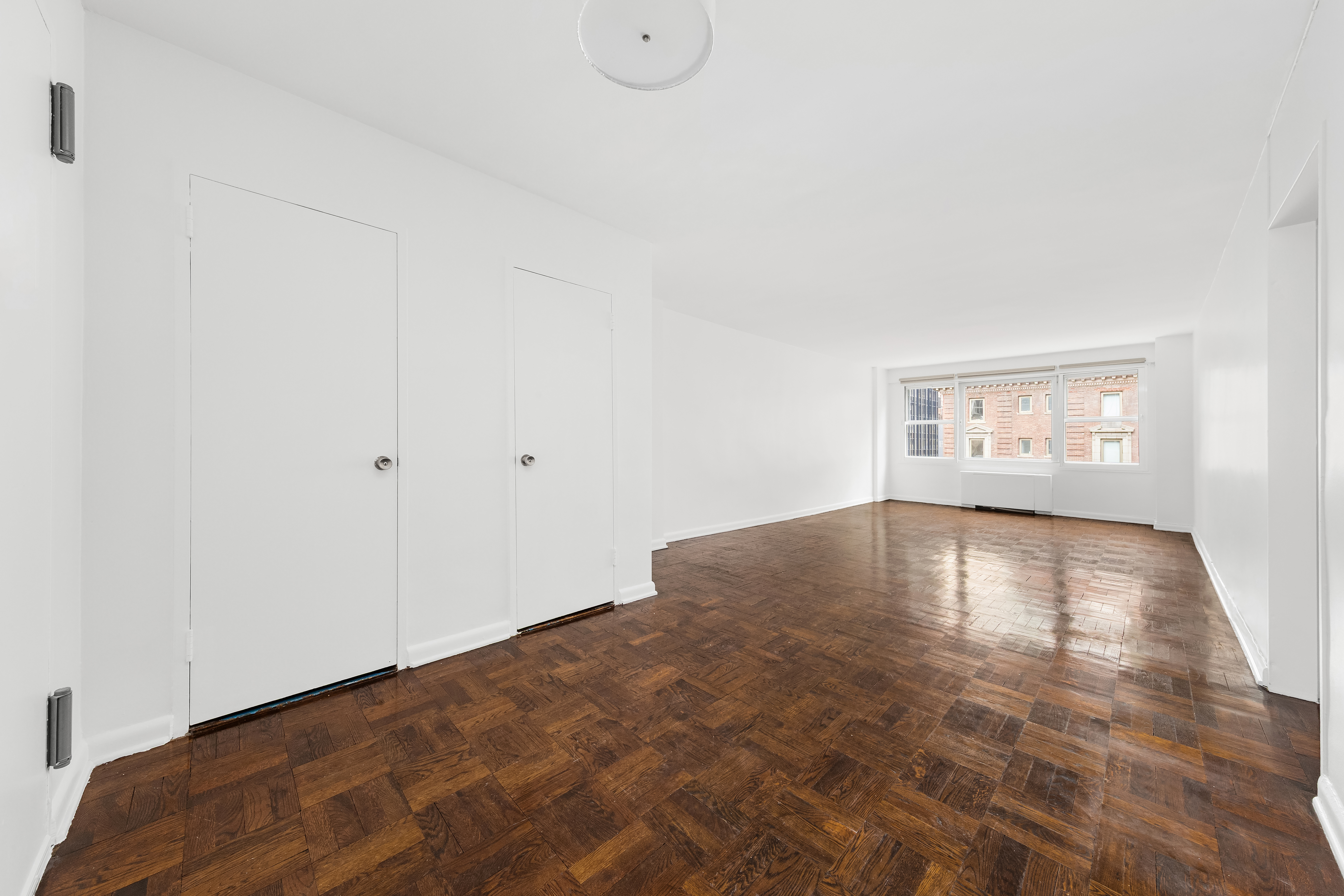 77 West 55th Street, Unit 17F Manhattan, NY 10019 - Photo 9 of 12 a view of empty room with wooden floor and fan