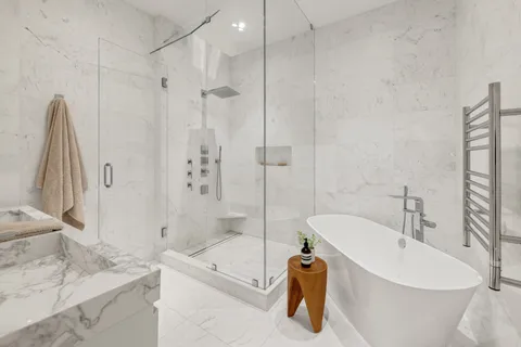 a white bath tub sitting next to a white sink and vanity