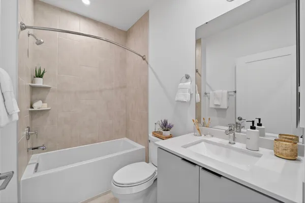 a bathroom with a granite countertop sink a toilet and shower
