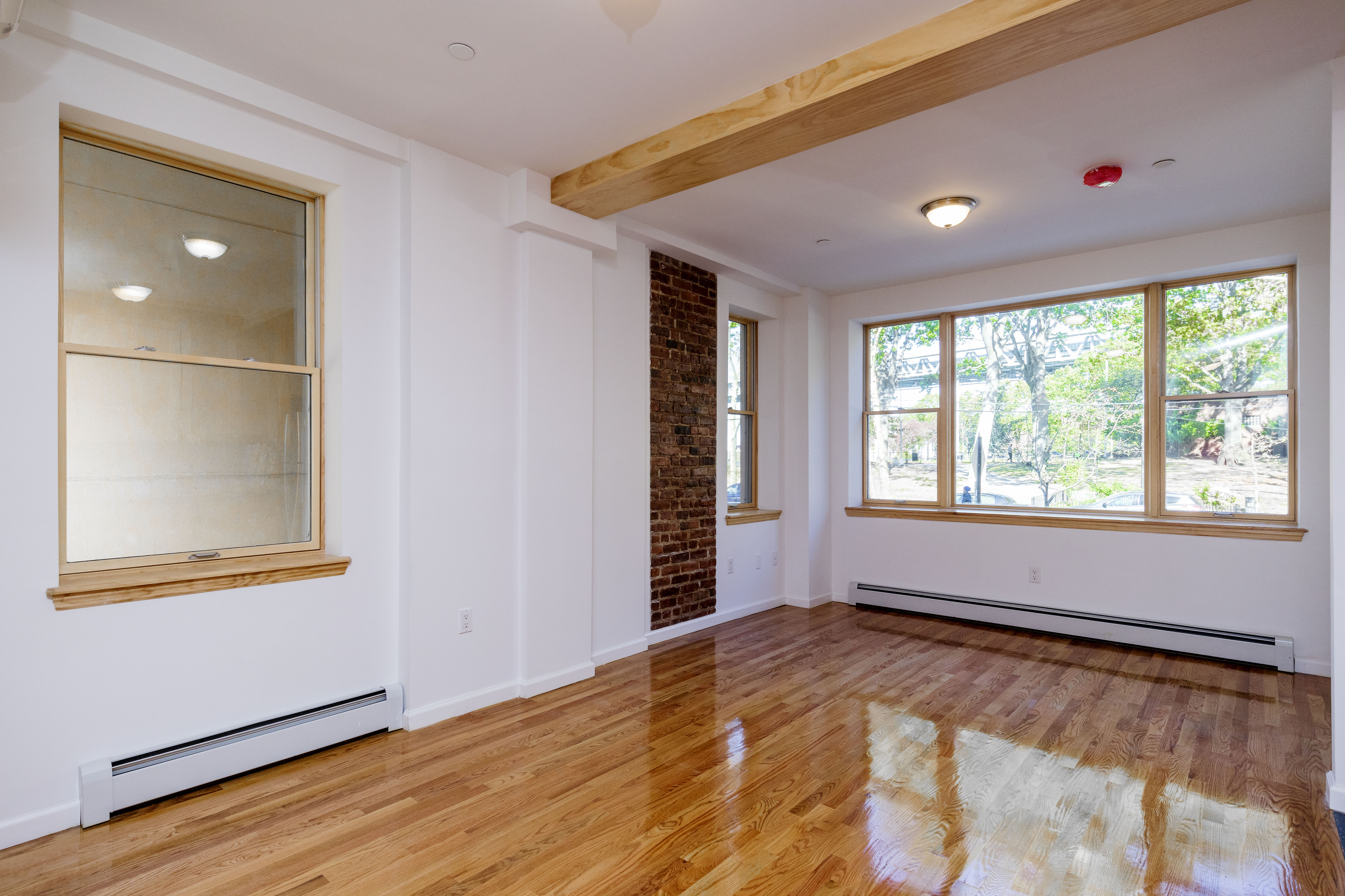18-10 Astoria Park South, Unit 1 Queens, NY 11102 - Photo 6 of 6 an empty room with wooden floor and windows