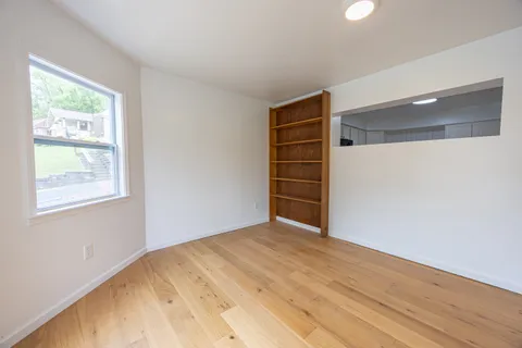 a view of empty room with wooden floor