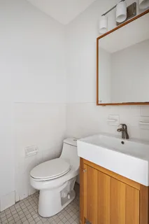 a bathroom with a toilet a sink and mirror