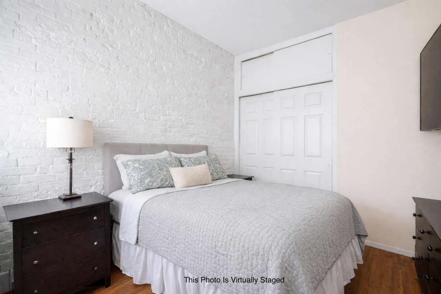 207 East 21st Street, Unit 5C Manhattan, NY 10010 - Photo 4 of 7 a bedroom with a bed and a lamp