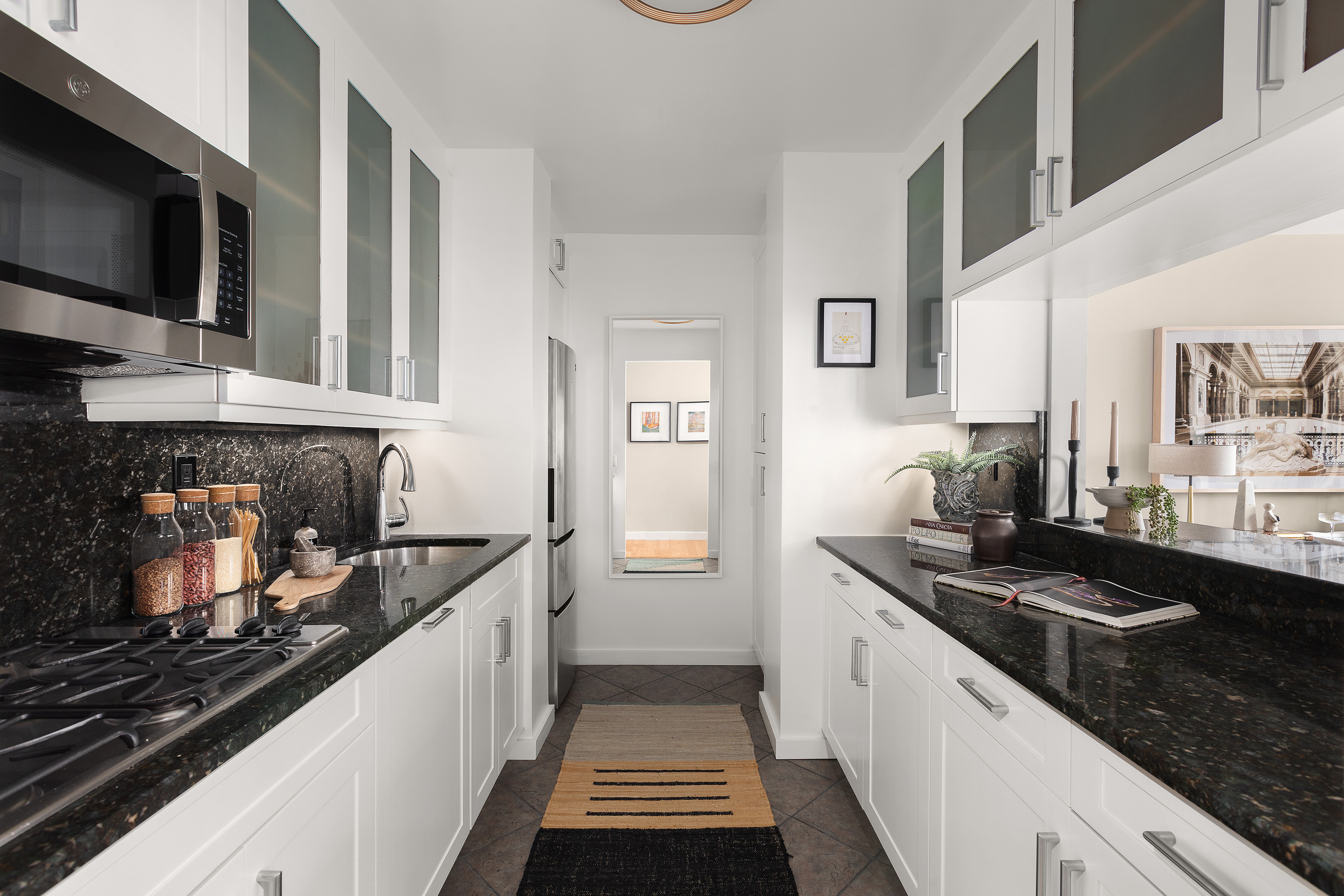 422 East 72nd Street, Unit 27C Manhattan, NY 10021 - Photo 8 of 25 a kitchen with stainless steel appliances a stove and a microwave
