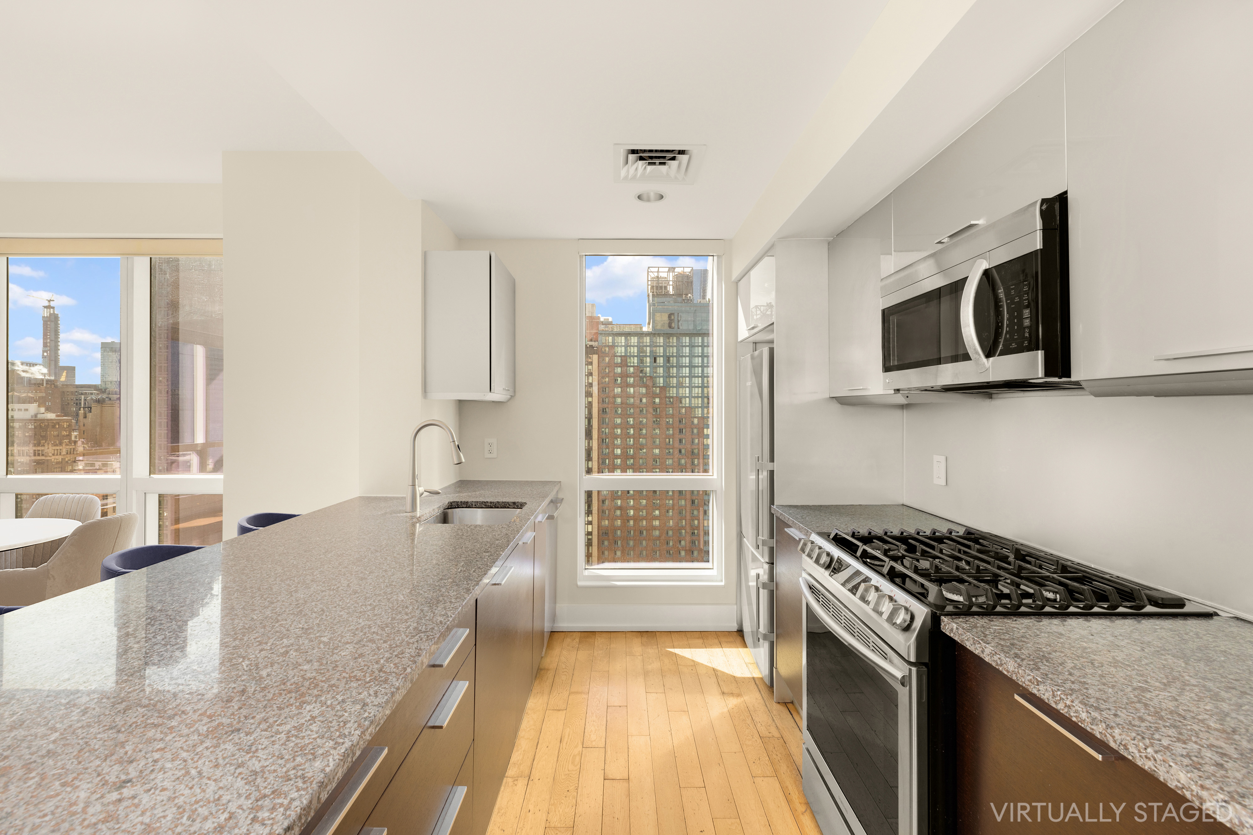 350 West 42nd Street, Unit 26G Manhattan, NY 10036 - Photo 5 of 11 a kitchen with granite countertop a stove and a sink